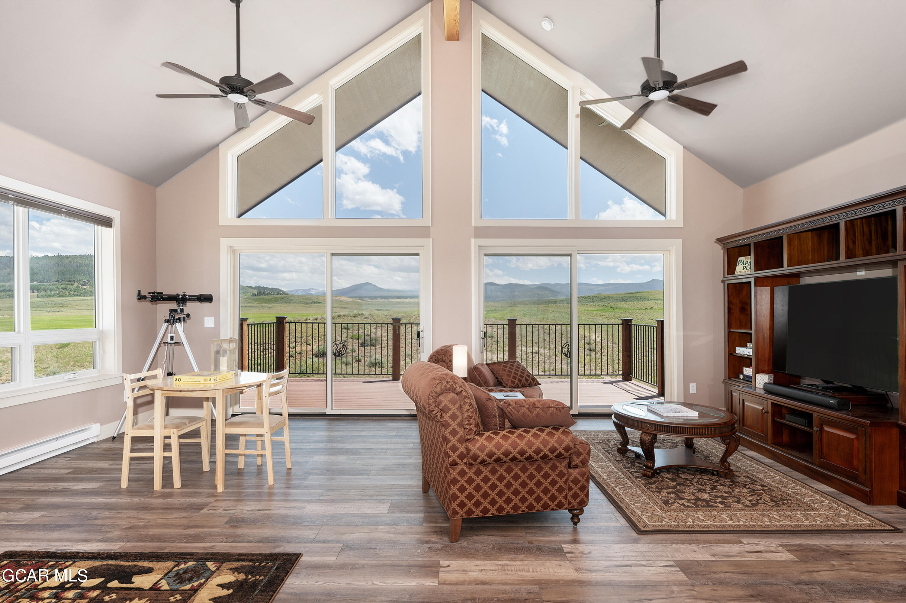 a living room with furniture a flat screen tv and a large window