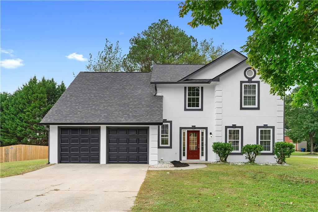 a front view of a house with a yard and garage