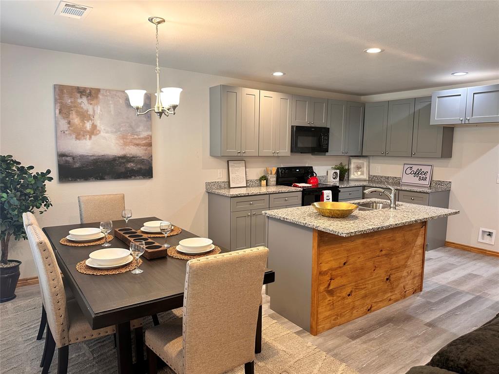 a kitchen with kitchen island granite countertop a sink a stove a kitchen island and chairs