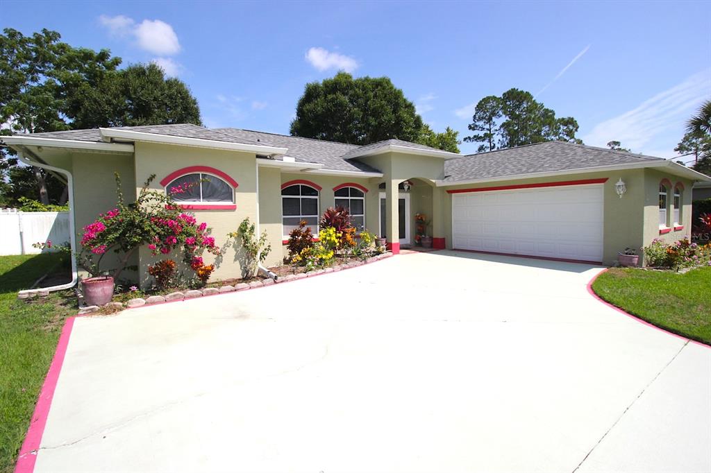 a front view of a house with a yard and potted plants