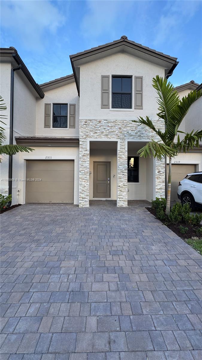 a front view of a house with a yard and garage