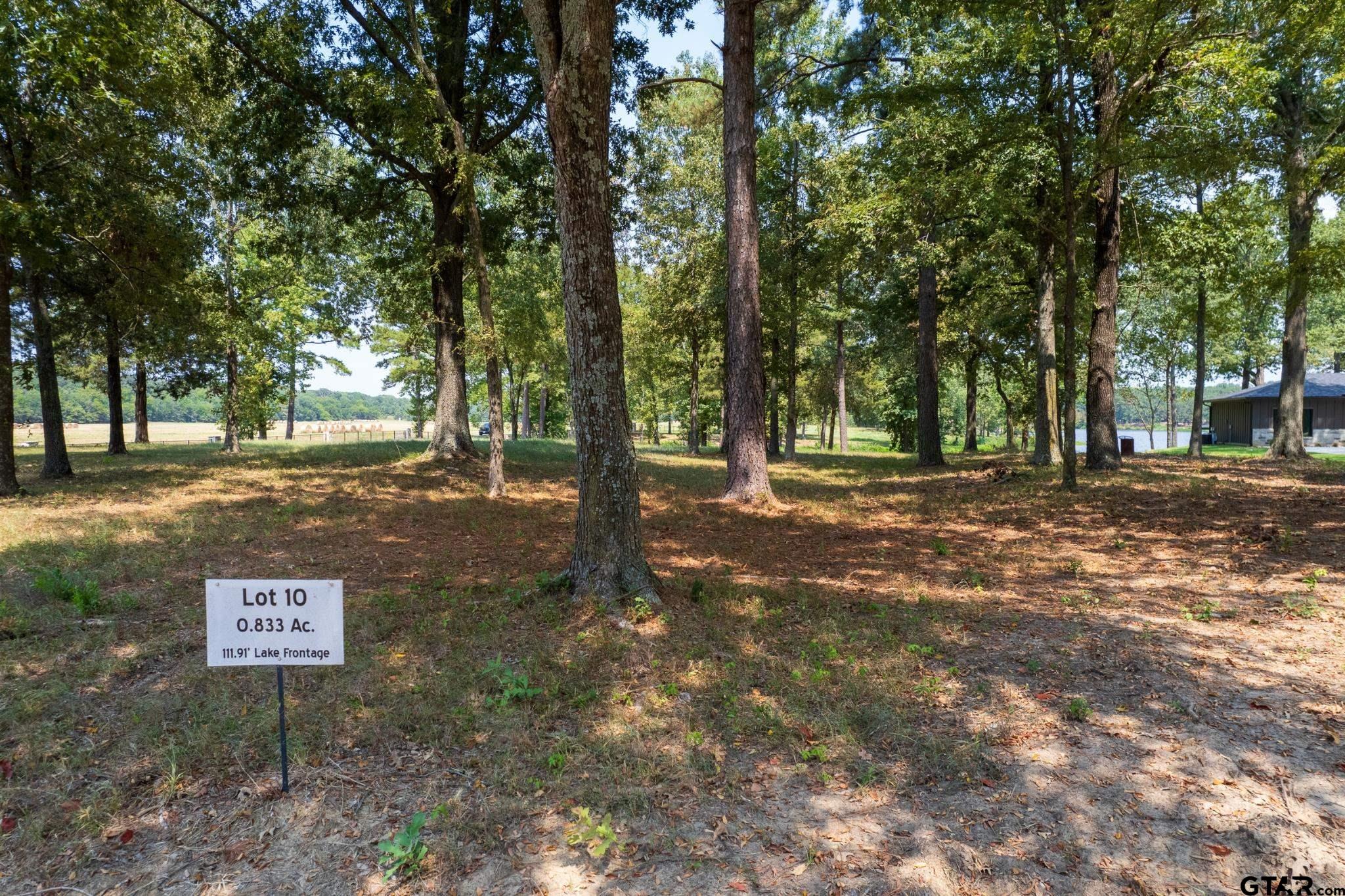 a sign board with tree in back