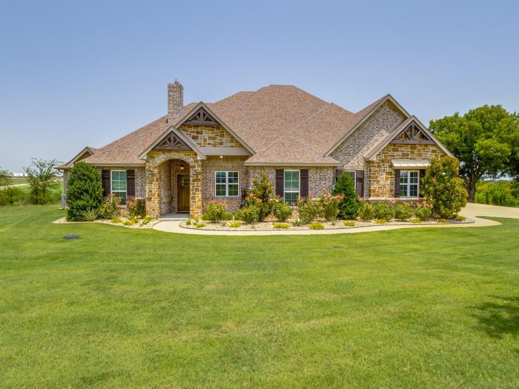 a front view of a house with swimming pool and green space