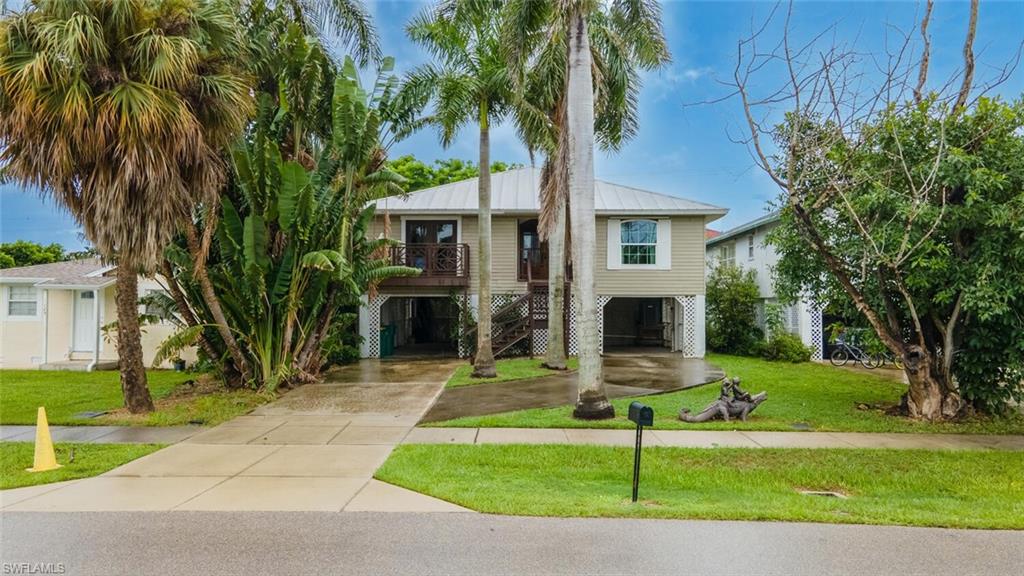 Florida Style home with a front yard and a 4-car storage