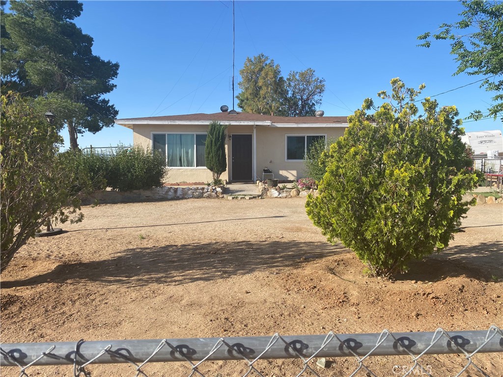 a front view of house with yard and trees around