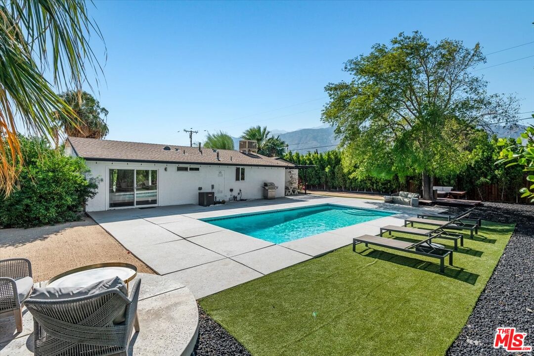 a view of a house with swimming pool and sitting area