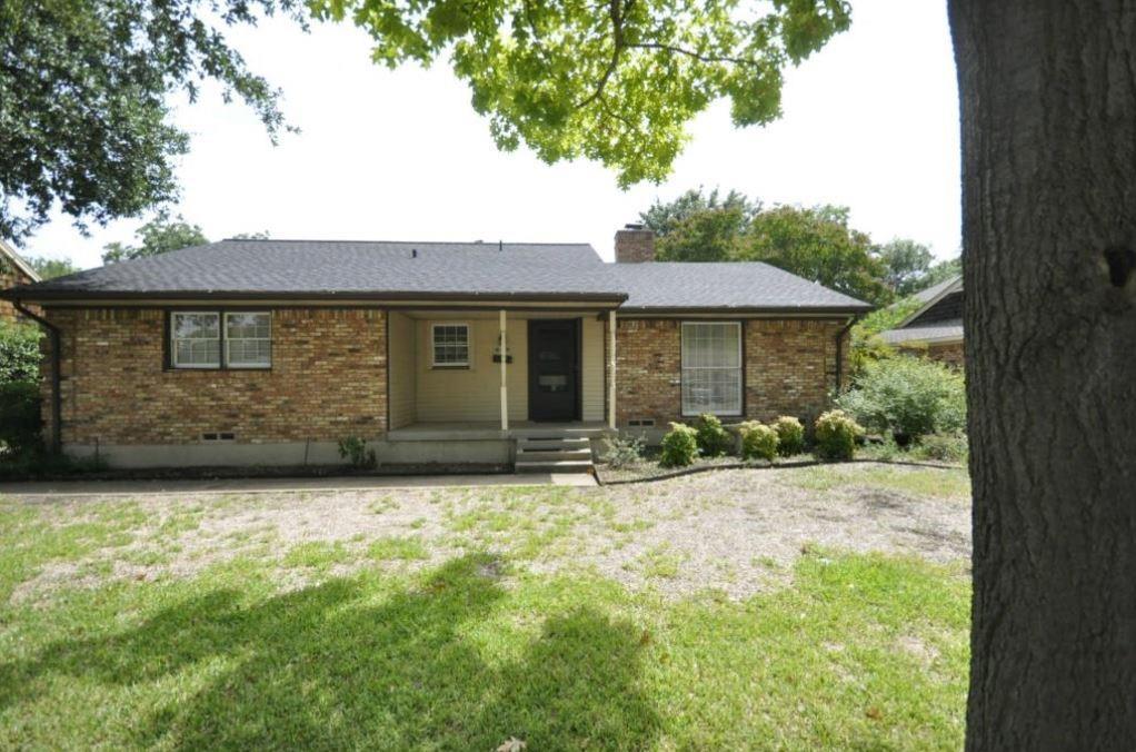 a front view of a house with yard and trees