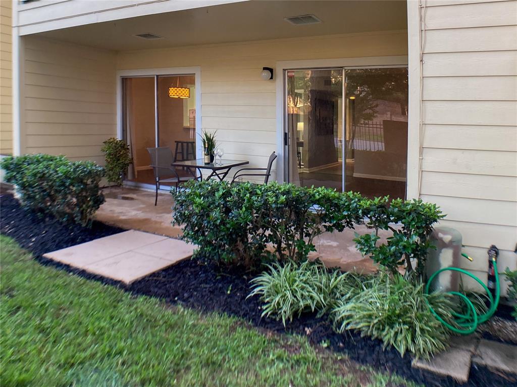 a view of a backyard with potted plants and a large tree