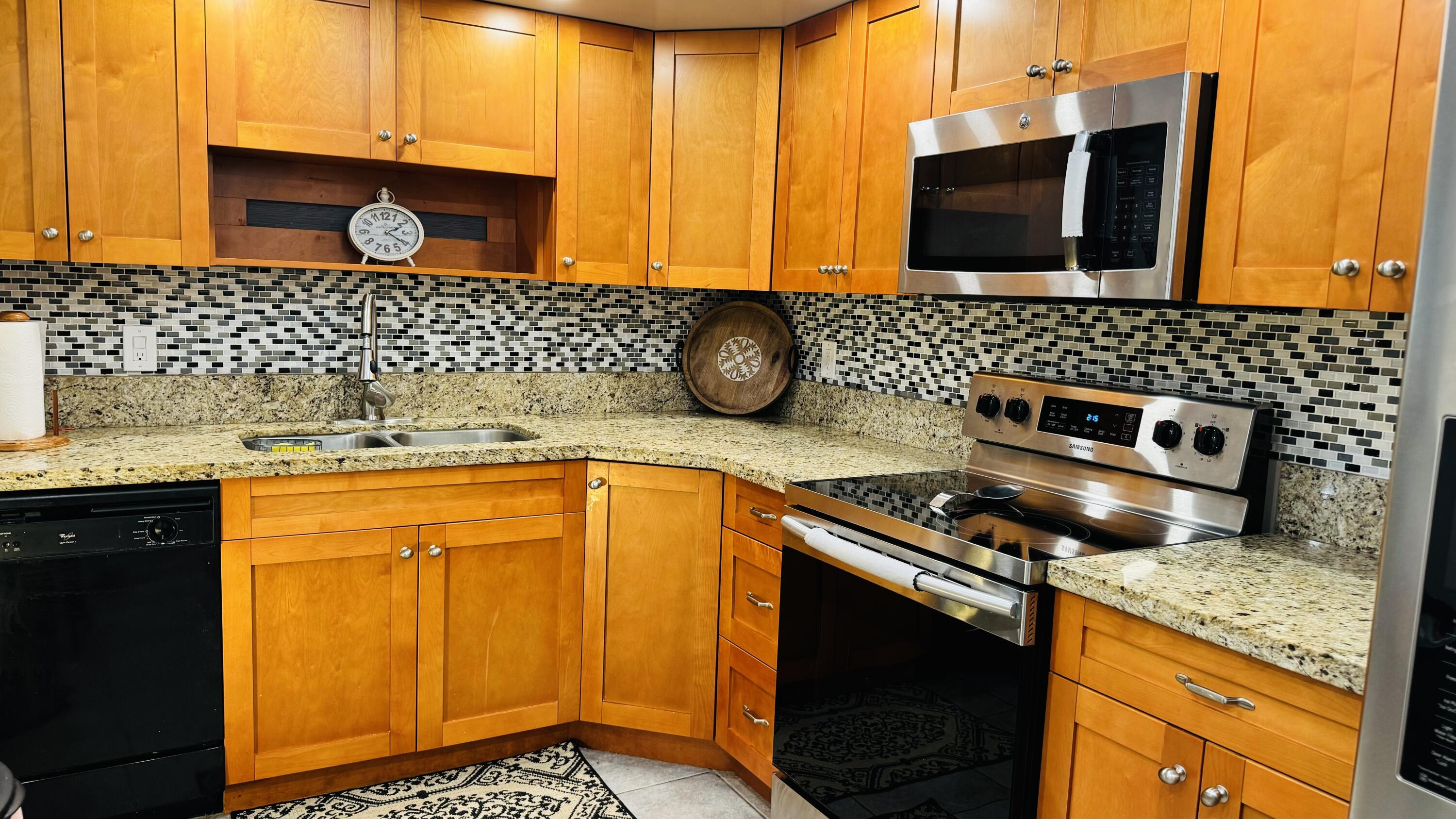 a kitchen with stainless steel appliances granite countertop a sink stove and microwave