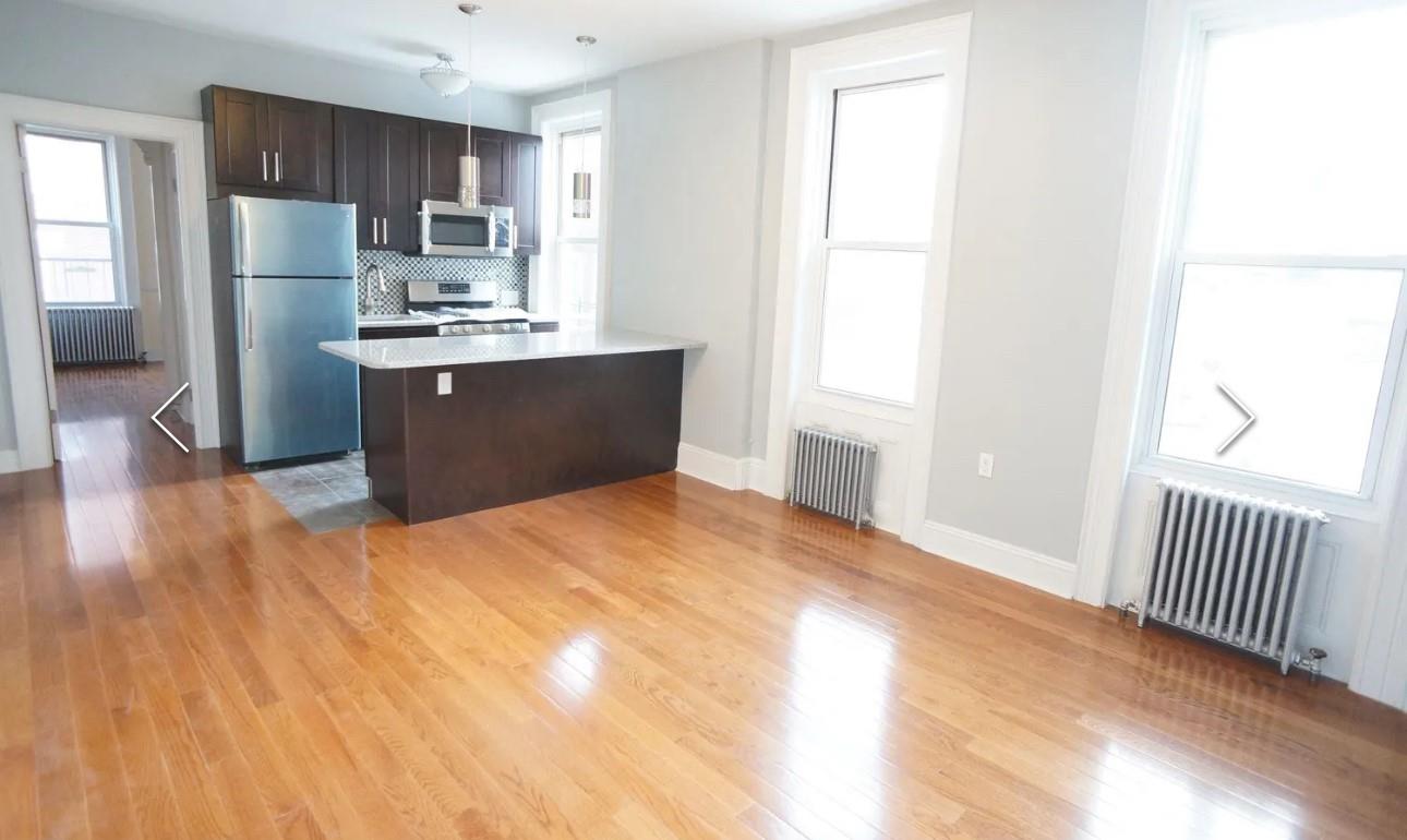 Kitchen featuring radiator, stainless steel appliances, and decorative light fixtures