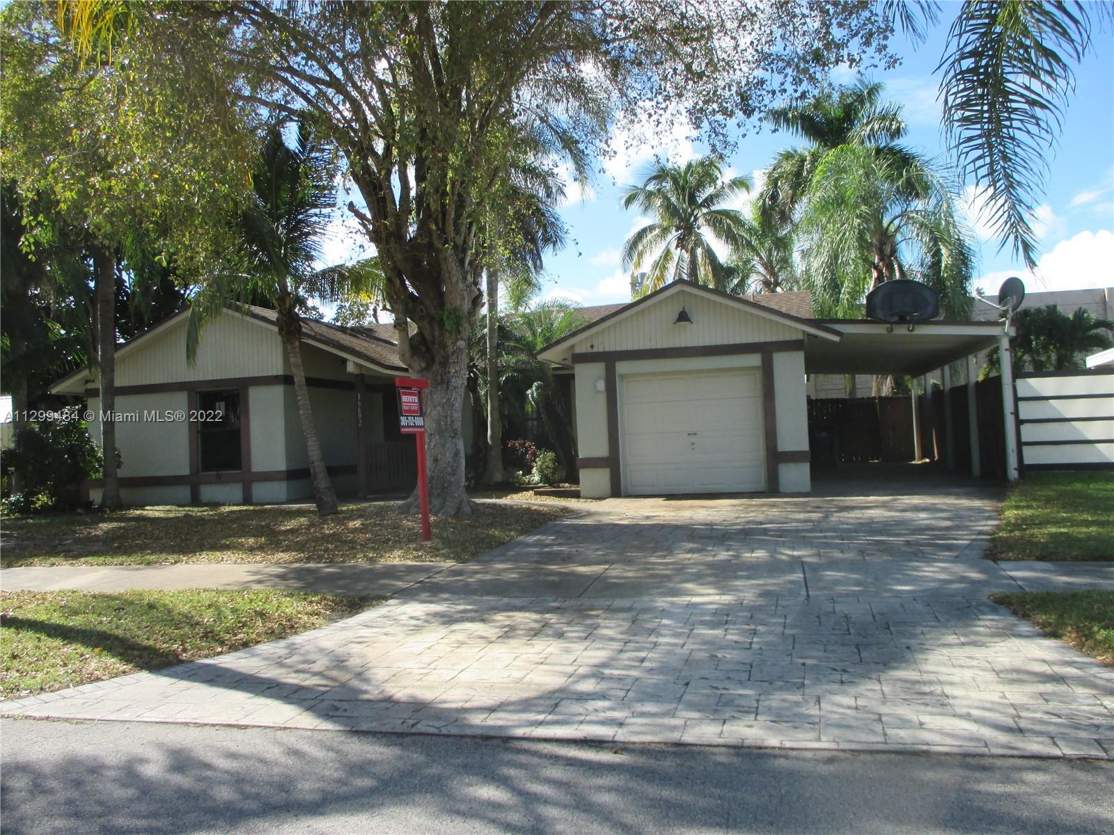 a front view of a house with a garden and trees