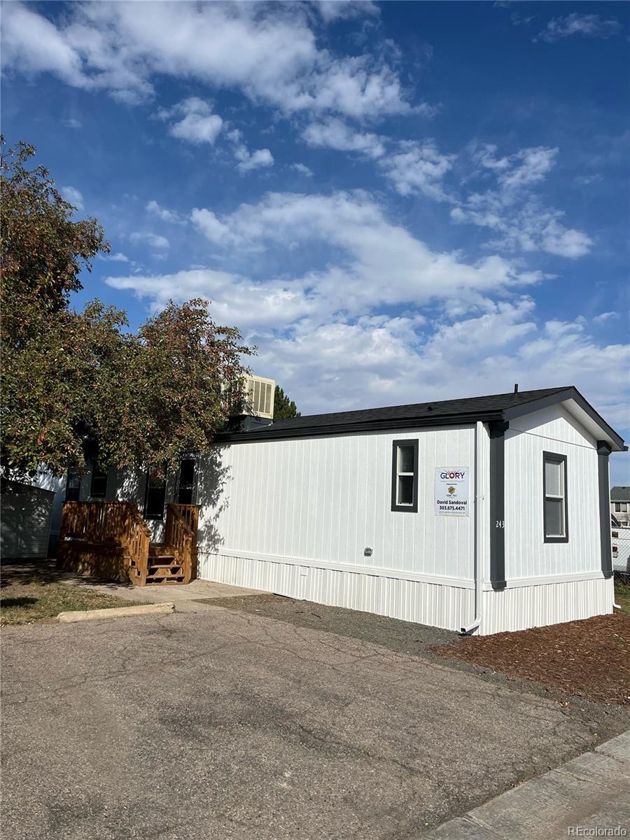 a view of house with yard and parking