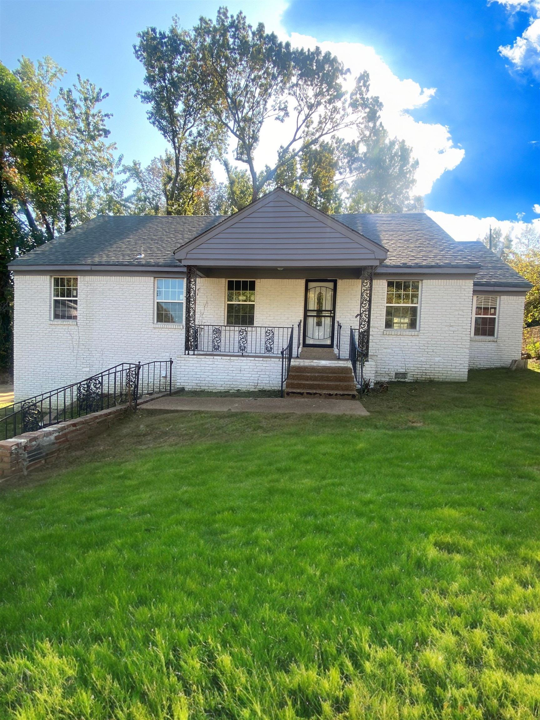 a front view of a house with a garden and yard