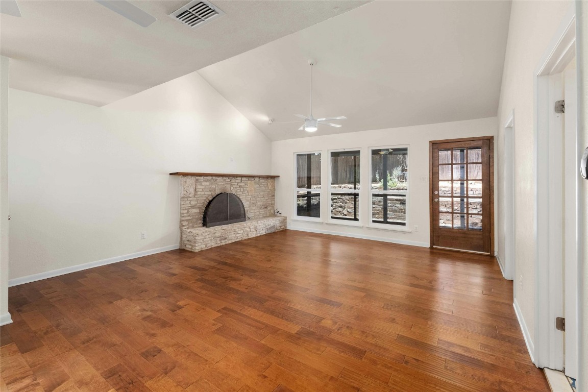 a view of an empty room with a fireplace and a window