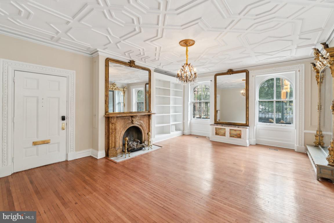 a view of a livingroom with a fireplace wooden floor and windows