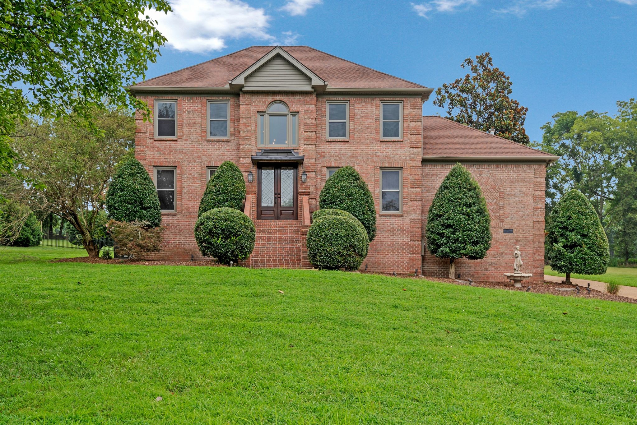 a front view of house with yard and green space