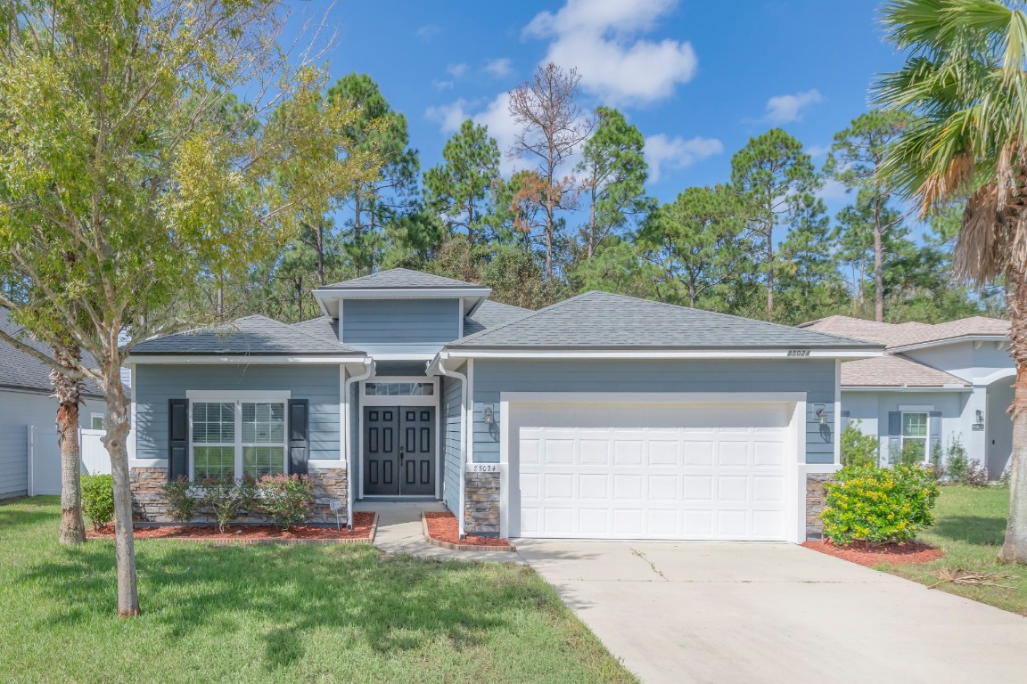 front view of a house with a yard and an trees