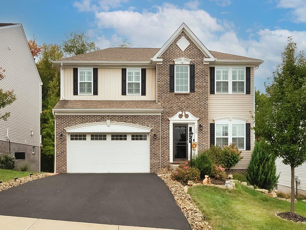 a front view of a house with a yard and garage