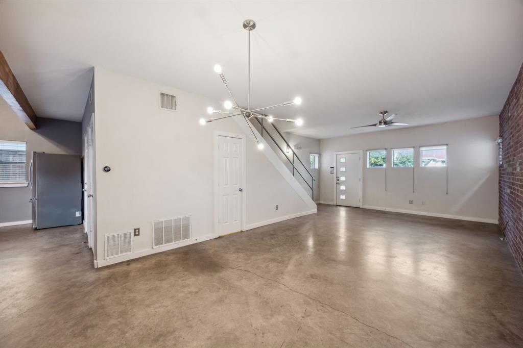 an empty room with windows and ceiling fan