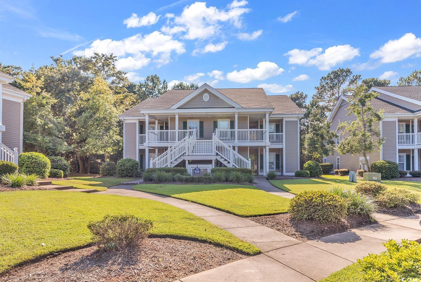 View of front of house with a front yard and cover