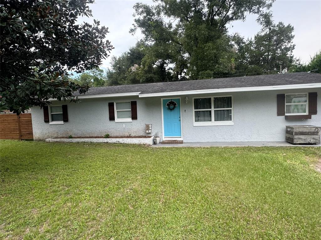 a front view of house with yard and trees