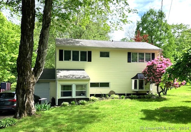 a front view of house with yard and green space