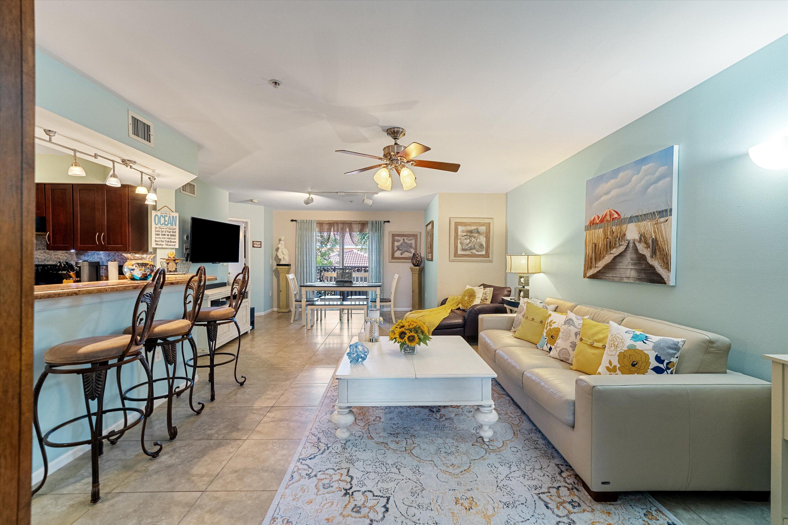 a living room with furniture kitchen view and a flat screen tv