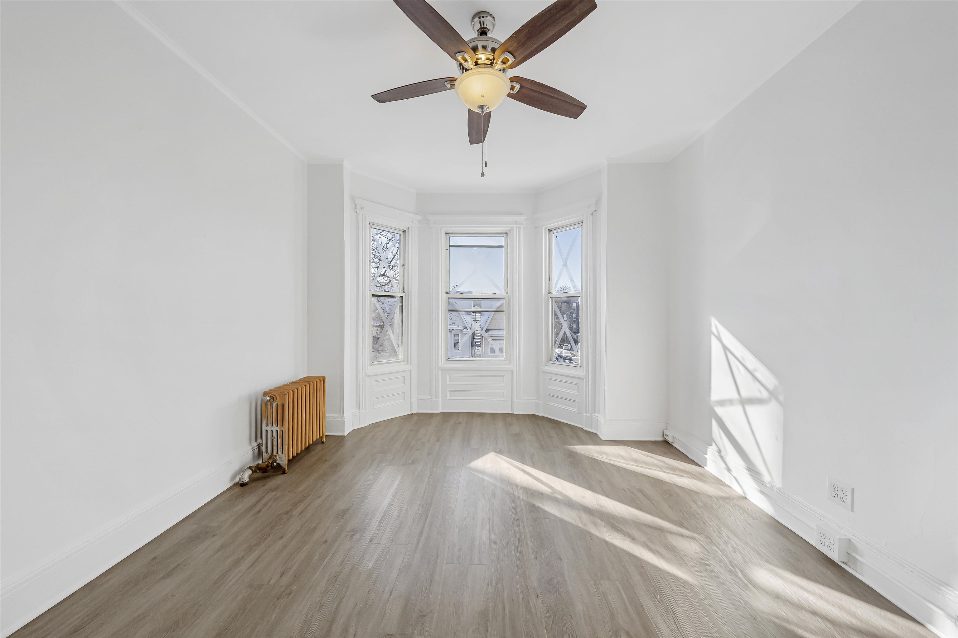 wooden floor in an empty room with a window