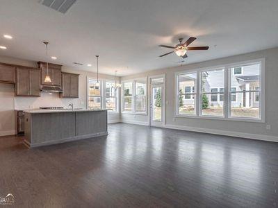 a living room with stainless steel appliances kitchen island granite countertop a stove a sink a refrigerator and a large window