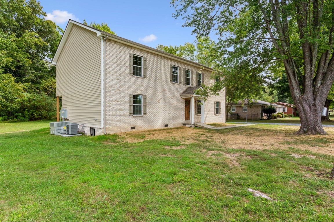 a view of a house with backyard and a tree