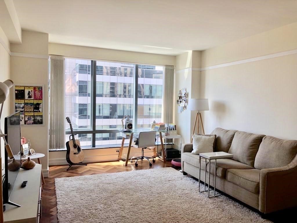 a living room with furniture and a floor to ceiling window