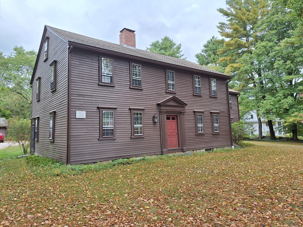 a brick house with a small yard and large tree