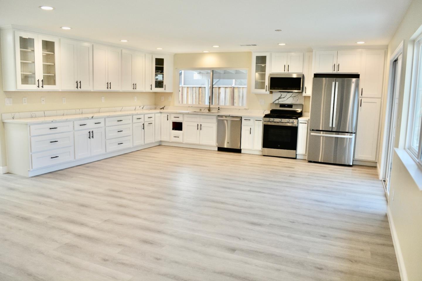 a large kitchen with stainless steel appliances and a refrigerator