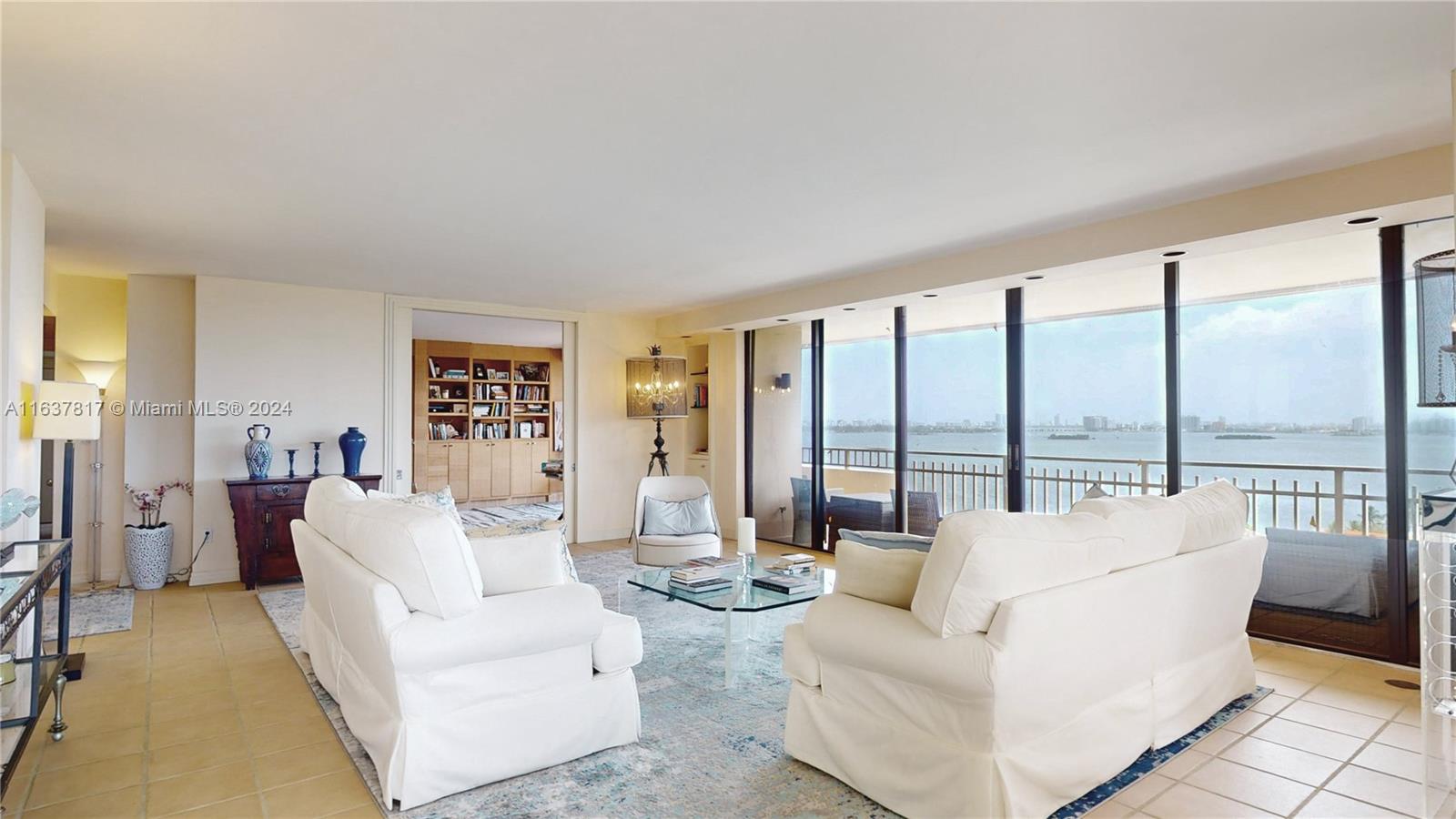 a living room with furniture and floor to ceiling windows