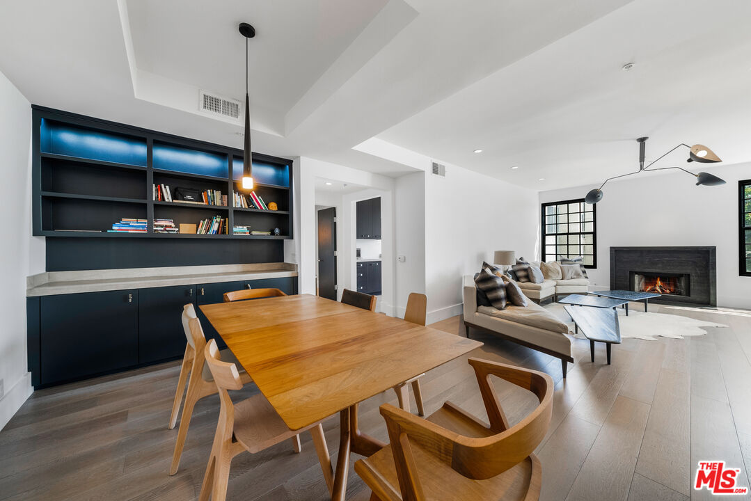 a view of a dining room with furniture a fireplace and wooden floor