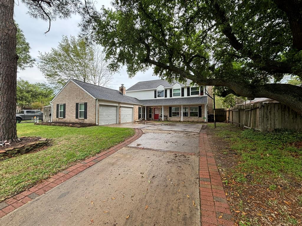 a front view of a house with a garden and tree