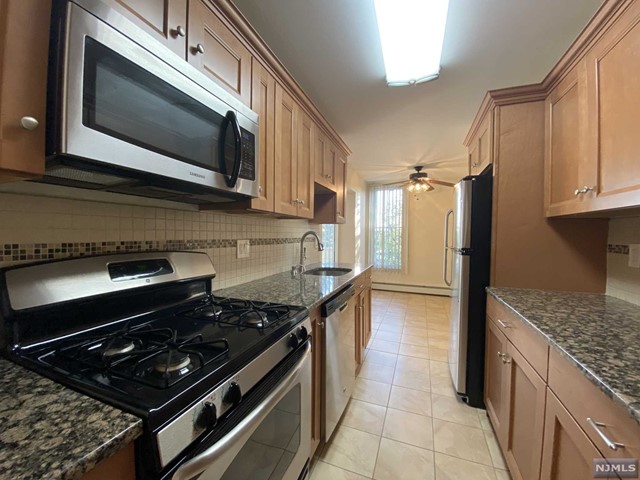 a kitchen with stainless steel appliances granite countertop a stove and a microwave