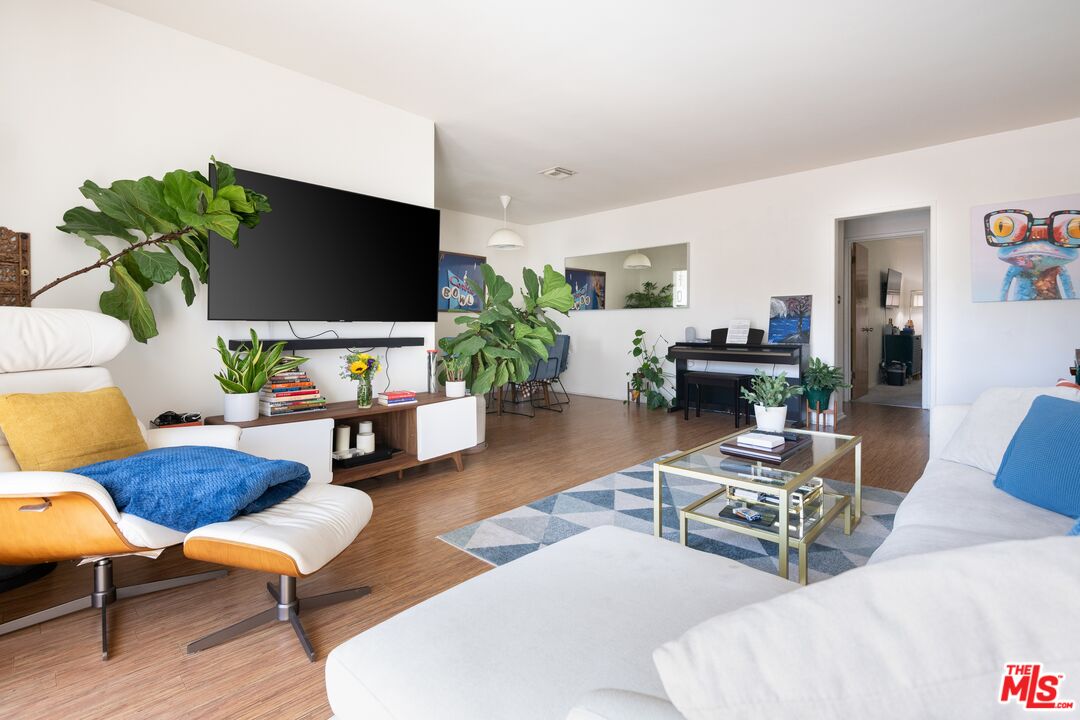 a living room with furniture a flat screen tv and a potted plant