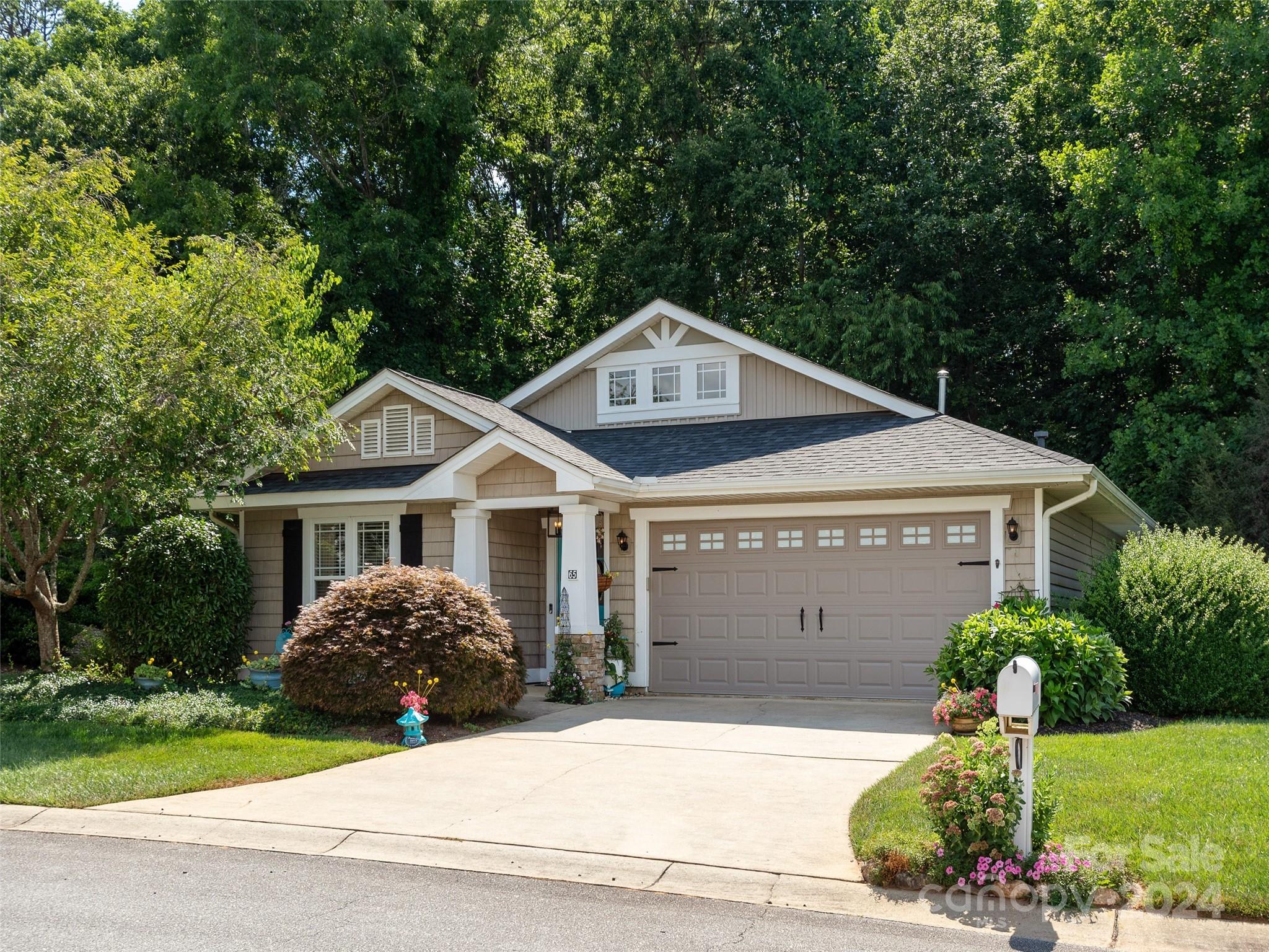 a front view of a house with a garden and plants