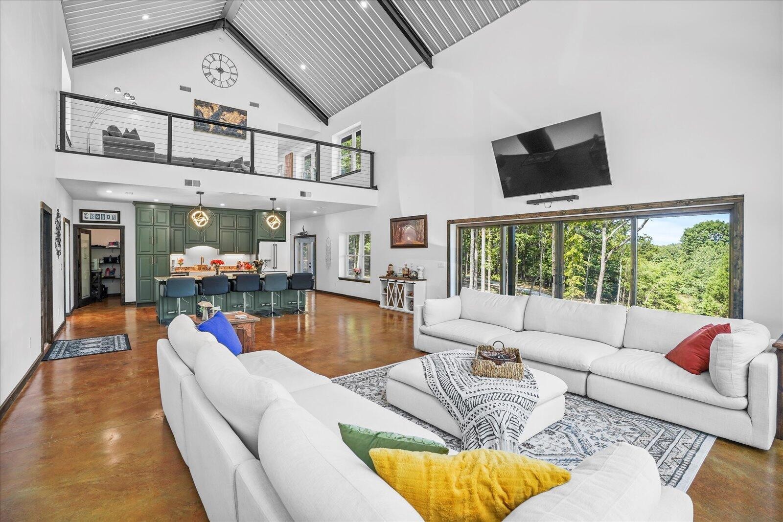 a living room with furniture a flat screen tv and a floor to ceiling window