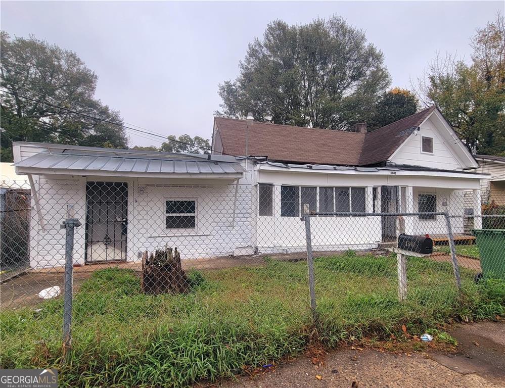 a front view of a house with a garden and trees