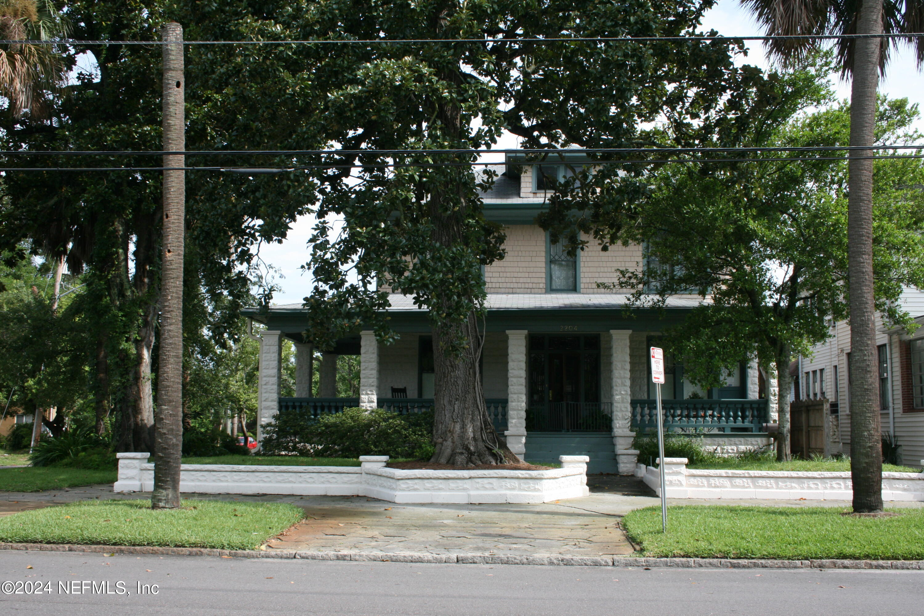 a view of a house with a tree in front of it