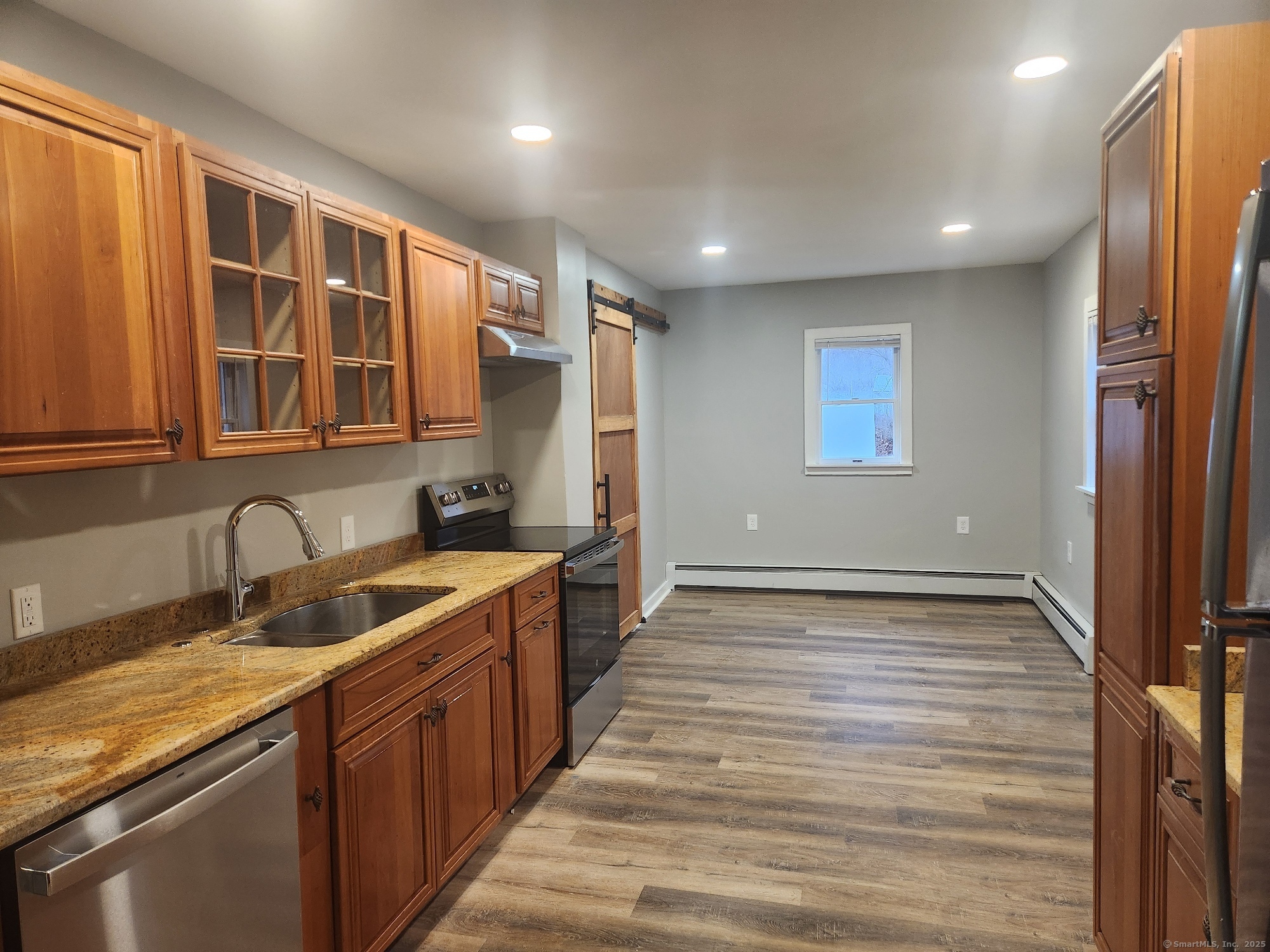 a kitchen with stainless steel appliances granite countertop a sink stove and cabinets