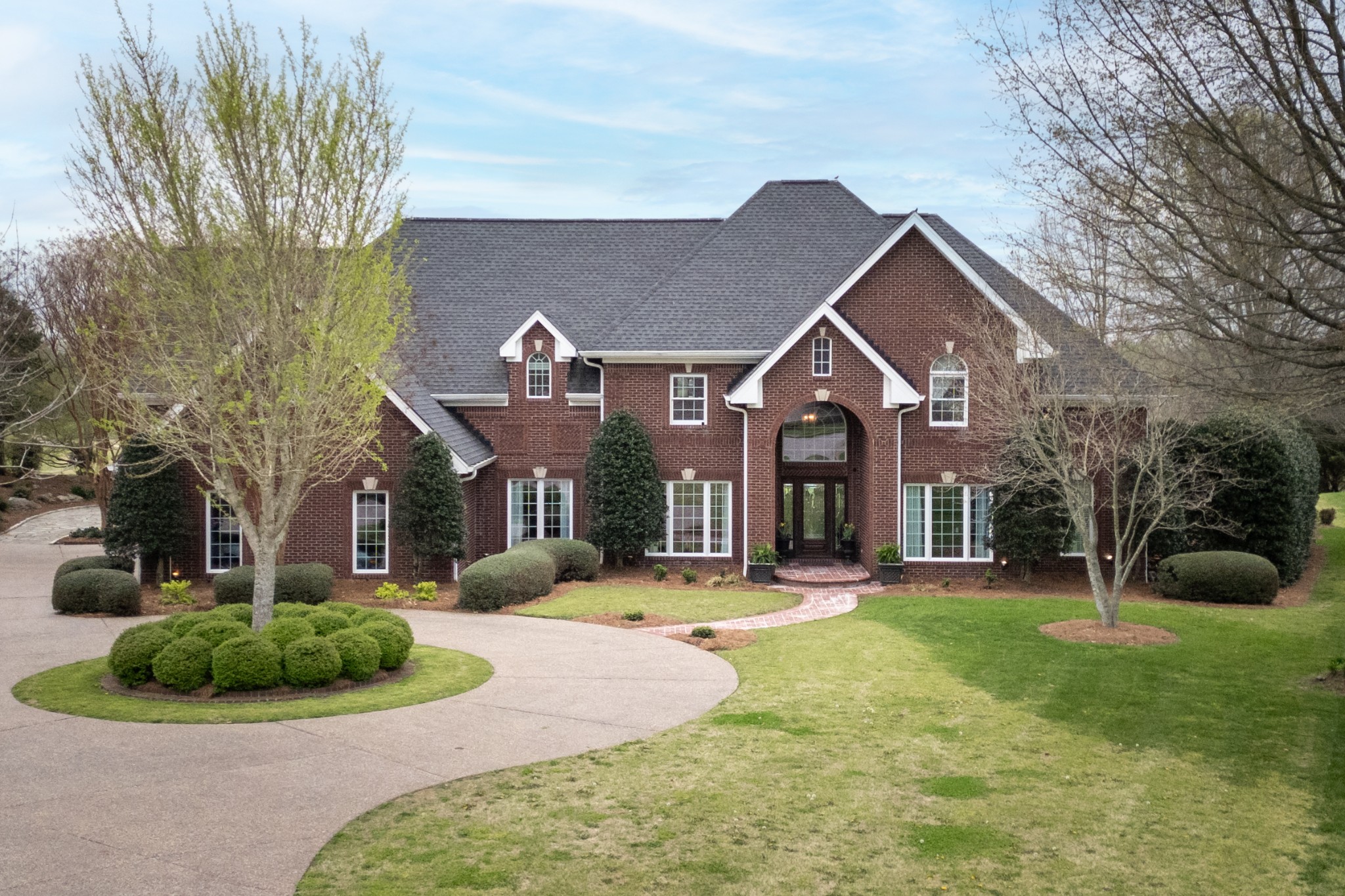 a front view of a house with a yard and potted plants