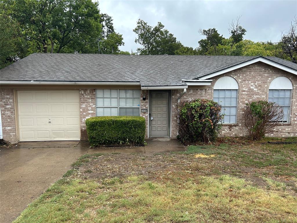 a view of a house with a garage and plants