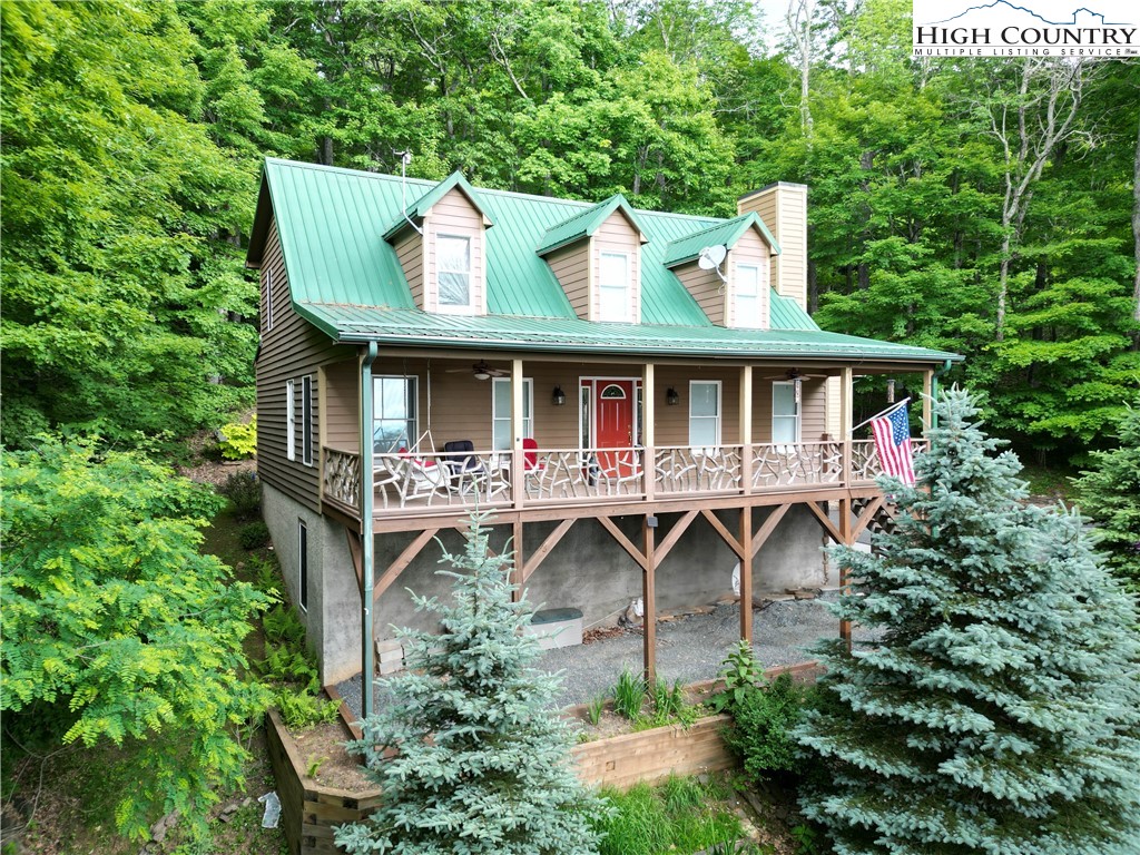 an aerial view of a house with balcony and trees al around