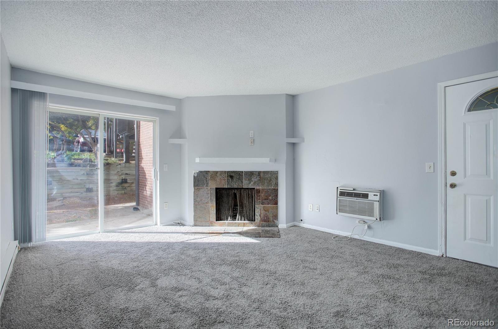 a view of an empty room with a fireplace and a window