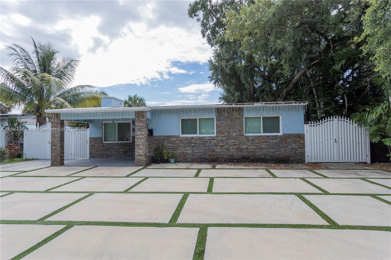 a front view of house with yard and trees around