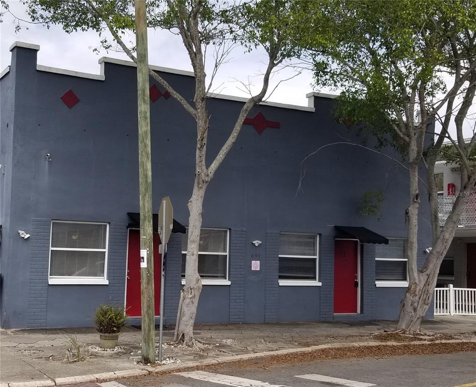 a front view of a house with a tree