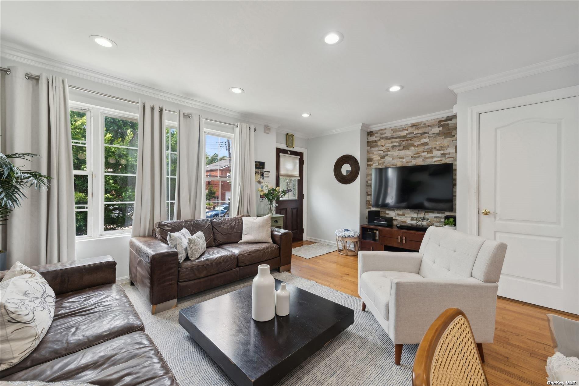 a living room with furniture a flat screen tv and a large window